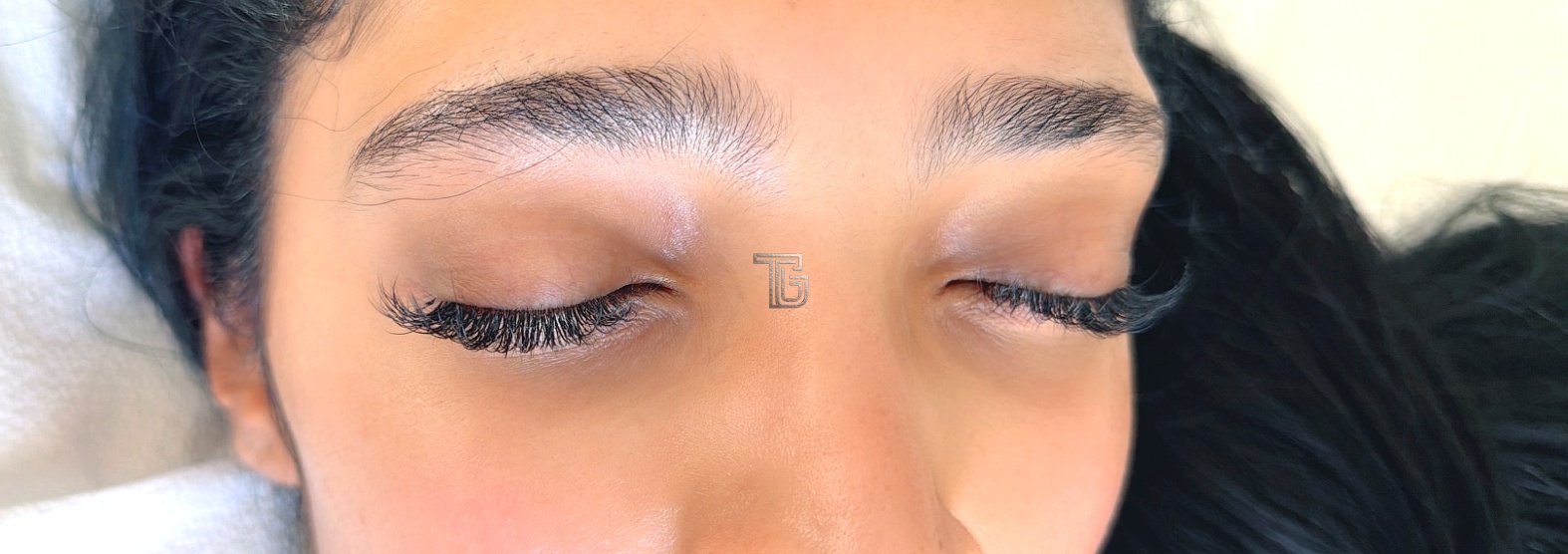 Finished lash set with eyes closed, showing the lengthened outer wing on both eyes